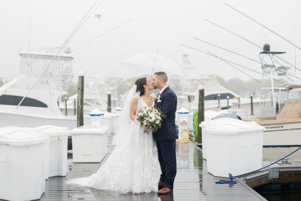 Waterfront wedding at Crystal Point Yacht Club in Point Pleasant NJ. Laura and Ryan's wedding day started at Crystal Point Inn which is located conveniently onsite for bride and groom as well as their guests to stay the night after long day of partying. Laura and Ryan's Crystal Point Yacht Club Wedding didn't go as planned due to rain but Laura and Ryan moved their wedding ceremony indoors and wedding portraits outside in the rain with clear umbrella. Rainy wedding day portraits can be very pretty and romantic. And towards the end of Laura and Ryan's wedding portrait the rain magically stopped for them and we were able to get some outdoor photos without the umbrella walking around Crystal Point Yacht Club. Then Laura and Ryan joined their wedding guests for the cocktail hour tgeb wedding reception at Crystal Point Yacht Club's beautiful reception room. Laura and Ryan's Crystal Point Yacht Club Point Pleasant NJ Wedding documented by Steve from Pearl Paper Studio. Pearl Paper Studio is here to capture real emotions, fun couples with non-traditional wedding stories, now we are booking small intimate backyard wedding, outdoor tent wedding, farm wedding, elopements, nyc elopements. We are currently booking fall 2023 and 2024 weddings in NJ, NY, Brooklyn and Long Island.