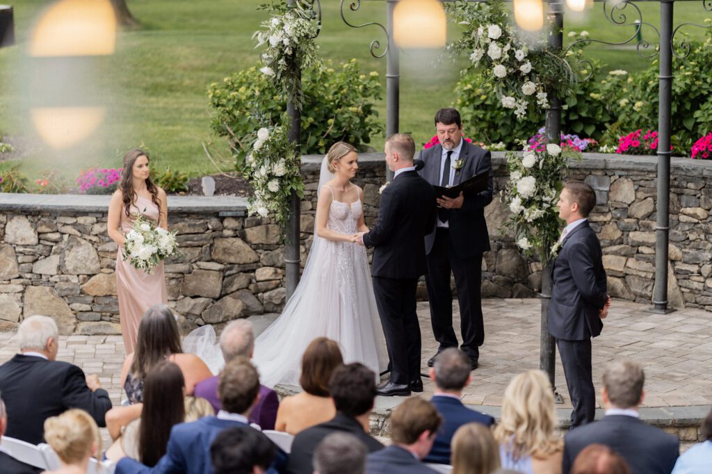 On June 2, 2024, I had the pleasure of photographing the beautiful wedding of Kristen Boonie and Ryan Piscopo at the stunning West Hills Country Club in Middletown, NY. The day was filled with love, joy, and picturesque moments that made for an unforgettable celebration.
Kristen and Ryan shared their first look on the lush green grass of West Hills Country Club, setting the tone for a day full of love and laughter. As we walked around the gorgeous property, we captured their wedding portraits amidst the vibrant blooms that provided a perfect backdrop for their special day.
The outdoor ceremony took place facing the golf course, offering a serene and peaceful view for all the guests. Blessed with amazing weather, the guests enjoyed the outdoors, reveling in the lush green field and the charming water fountain.
As the sun began to set, the reception music by Spin Doctor Entertainment filled the air, and guests moved into the beautifully set up tent. The floral decor by Deja Vu Floral Design added an extra touch of elegance, making the space under the expansive tent shine even more beautifully.
The reception began with Kristen and Ryan making their grand entrance, and the celebration kicked off in high spirits. Surrounded by their family and friends, they celebrated their love and new journey together at the picturesque West Hills Country Club.
West Hills Country Club provided a breathtaking setting for Kristen and Ryan's wedding day, with its lush landscapes, beautiful blooms, and elegant spaces. It was a day to remember, filled with love, laughter, and stunning scenery.
Kristen and Ryan West Hills Country Club NY Wedding photographed by MJ from Pearl Paper Studio. Pearl Paper Studio is here to capture real emotions, fun couples with non-traditional wedding stories, now we are booking small intimate backyard wedding, outdoor tent wedding, farm wedding, elopements, nyc elopements. We are currently booking 2024 weddings in NJ, NY, Brooklyn and Long Island.