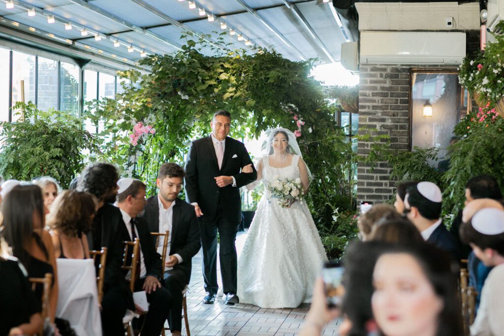 Nikki and Spencer’s wedding day was a perfect blend of heartfelt moments, breathtaking views, and joyous celebration in the heart of Manhattan.
The day began at the Hyatt Herald Square, where both the bride and groom got ready. Before heading out, Nikki and Spencer each shared emotional first-look moments with their parents, setting a beautiful tone for the day ahead.
The couple then made their way to the iconic New York Public Library and Bryant Park for their formal photos. Surrounded by their wedding party and family, the historic architecture and lush park provided a stunning backdrop for capturing unforgettable memories.
The ceremony took place on the rooftop Terrace at Midtown Loft & Terrace. This incredible space, featuring a retractable enclosed rooftop, offers a lush landscaped setting with sweeping 360-degree views of the Manhattan skyline. Guests were treated to vistas of iconic landmarks, including the Empire State Building and Marble Collegiate Church, making the moment even more magical.
After the ceremony, everyone moved indoors to the elegant Loft, which boasts high ceilings and large windows that frame the city’s skyline beautifully. The space perfectly complemented Nikki and Spencer’s vision for their wedding, providing a warm and stylish setting for the evening’s festivities.
The newlyweds shared laughter, happy tears, and countless unforgettable moments with their friends and family. As the night unfolded, the dance floor was alive with celebration, marking the perfect end to Nikki and Spencer’s extraordinary day at Midtown Loft & Terrace.
Congratulations, Nikki and Spencer! Your wedding was a true reflection of your love and joy, and I’m so honored to have captured it all.
Nikki and Spencer Midtown Loft and Terrace NY Wedding photographed by MJ from Pearl Paper Studio. Pearl Paper Studio is here to capture real emotions, fun couples with non-traditional wedding stories, now we are booking small intimate backyard wedding, outdoor tent wedding, farm wedding, elopements, nyc elopements. We are currently booking 2025 and 2026 weddings in NJ, Manhattan, Hudson Valley NY, Brooklyn and Long Island.