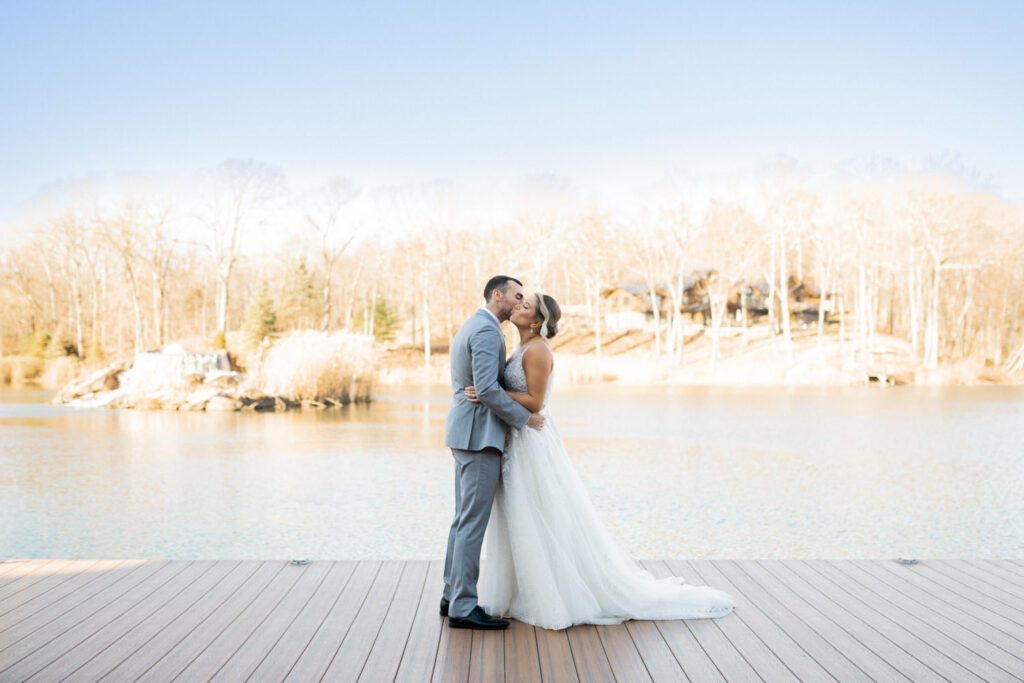 Emily and Frank Rock Island Lake Club, NJ 
Winter weddings are magical, and Emily and Frank’s November celebration at Rock Island Lake Club in Sparta, NJ, was the perfect example of just how enchanting they can be! Who says winter weddings can’t be fun? Despite the chilly weather, their special day was filled with warmth, laughter, and love—a true testament to their joyful spirits and the magic of this incredible venue.
Emily and Frank embraced the crisp November air with an outdoor ceremony by the picturesque lake at Rock Island Lake Club. The serene water, framed by the natural beauty of the surrounding landscape, created an unforgettable backdrop for their vows. Guests bundled up in cozy wraps and blankets, their smiles radiating as they witnessed the couple’s heartfelt promises. The venue’s dedicated team ensured every detail was perfectly executed, making the ceremony seamless.
After the ceremony, the celebration continued with one of the best cocktail hours in all of New Jersey. Rock Island Lake Club is renowned for its exceptional cuisine and creative presentation, and this event was no exception. Guests enjoyed an array of delicious hors d’oeuvres and drinks while mingling in the warm and inviting indoor spaces, thoughtfully designed to complement the venue’s lakeside charm.
The reception was a lively affair, with the dance floor packed from the first song to the last. Friends and family came together to celebrate Emily and Frank’s love, creating an atmosphere of pure joy. The stunning reception room at Rock Island Lake Club, with its elegant décor and large windows overlooking the lake, provided the perfect setting for a night of dancing, laughter, and unforgettable memories.
Rock Island Lake Club truly excels at hosting weddings year-round, but winter weddings here have a special kind of magic. From the attentive staff to the breathtaking views, every aspect of this venue enhances the celebration. Emily and Frank’s wedding day is proof that even on the coldest days, love and happiness can shine brighter than ever.
If you’re considering a winter wedding, Rock Island Lake Club is the perfect venue to bring your vision to life. Emily and Frank’s celebration was a testament to the beauty of the season and the power of love to warm even the chilliest of days.
Emily and Frank Rock Island Lake Club NJ Wedding photographed by Steve from Pearl Paper Studio. Pearl Paper Studio is here to capture real emotions, fun couples with non-traditional wedding stories, now we are booking small intimate backyard wedding, outdoor tent wedding, farm wedding, elopements, nyc elopements. We are currently booking 2025 and 2026 weddings in NJ, Manhattan, Hudson Valley NY, Brooklyn and Long Island.
