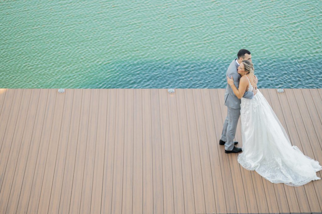 Emily and Frank Rock Island Lake Club, NJ 
Winter weddings are magical, and Emily and Frank’s November celebration at Rock Island Lake Club in Sparta, NJ, was the perfect example of just how enchanting they can be! Who says winter weddings can’t be fun? Despite the chilly weather, their special day was filled with warmth, laughter, and love—a true testament to their joyful spirits and the magic of this incredible venue.
Emily and Frank embraced the crisp November air with an outdoor ceremony by the picturesque lake at Rock Island Lake Club. The serene water, framed by the natural beauty of the surrounding landscape, created an unforgettable backdrop for their vows. Guests bundled up in cozy wraps and blankets, their smiles radiating as they witnessed the couple’s heartfelt promises. The venue’s dedicated team ensured every detail was perfectly executed, making the ceremony seamless.
After the ceremony, the celebration continued with one of the best cocktail hours in all of New Jersey. Rock Island Lake Club is renowned for its exceptional cuisine and creative presentation, and this event was no exception. Guests enjoyed an array of delicious hors d’oeuvres and drinks while mingling in the warm and inviting indoor spaces, thoughtfully designed to complement the venue’s lakeside charm.
The reception was a lively affair, with the dance floor packed from the first song to the last. Friends and family came together to celebrate Emily and Frank’s love, creating an atmosphere of pure joy. The stunning reception room at Rock Island Lake Club, with its elegant décor and large windows overlooking the lake, provided the perfect setting for a night of dancing, laughter, and unforgettable memories.
Rock Island Lake Club truly excels at hosting weddings year-round, but winter weddings here have a special kind of magic. From the attentive staff to the breathtaking views, every aspect of this venue enhances the celebration. Emily and Frank’s wedding day is proof that even on the coldest days, love and happiness can shine brighter than ever.
If you’re considering a winter wedding, Rock Island Lake Club is the perfect venue to bring your vision to life. Emily and Frank’s celebration was a testament to the beauty of the season and the power of love to warm even the chilliest of days.
Emily and Frank Rock Island Lake Club NJ Wedding photographed by Steve from Pearl Paper Studio. Pearl Paper Studio is here to capture real emotions, fun couples with non-traditional wedding stories, now we are booking small intimate backyard wedding, outdoor tent wedding, farm wedding, elopements, nyc elopements. We are currently booking 2025 and 2026 weddings in NJ, Manhattan, Hudson Valley NY, Brooklyn and Long Island.
