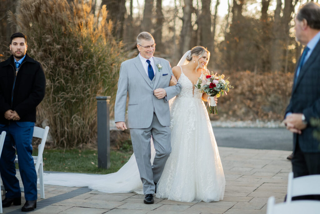 Emily and Frank Rock Island Lake Club, NJ 
Winter weddings are magical, and Emily and Frank’s November celebration at Rock Island Lake Club in Sparta, NJ, was the perfect example of just how enchanting they can be! Who says winter weddings can’t be fun? Despite the chilly weather, their special day was filled with warmth, laughter, and love—a true testament to their joyful spirits and the magic of this incredible venue.
Emily and Frank embraced the crisp November air with an outdoor ceremony by the picturesque lake at Rock Island Lake Club. The serene water, framed by the natural beauty of the surrounding landscape, created an unforgettable backdrop for their vows. Guests bundled up in cozy wraps and blankets, their smiles radiating as they witnessed the couple’s heartfelt promises. The venue’s dedicated team ensured every detail was perfectly executed, making the ceremony seamless.
After the ceremony, the celebration continued with one of the best cocktail hours in all of New Jersey. Rock Island Lake Club is renowned for its exceptional cuisine and creative presentation, and this event was no exception. Guests enjoyed an array of delicious hors d’oeuvres and drinks while mingling in the warm and inviting indoor spaces, thoughtfully designed to complement the venue’s lakeside charm.
The reception was a lively affair, with the dance floor packed from the first song to the last. Friends and family came together to celebrate Emily and Frank’s love, creating an atmosphere of pure joy. The stunning reception room at Rock Island Lake Club, with its elegant décor and large windows overlooking the lake, provided the perfect setting for a night of dancing, laughter, and unforgettable memories.
Rock Island Lake Club truly excels at hosting weddings year-round, but winter weddings here have a special kind of magic. From the attentive staff to the breathtaking views, every aspect of this venue enhances the celebration. Emily and Frank’s wedding day is proof that even on the coldest days, love and happiness can shine brighter than ever.
If you’re considering a winter wedding, Rock Island Lake Club is the perfect venue to bring your vision to life. Emily and Frank’s celebration was a testament to the beauty of the season and the power of love to warm even the chilliest of days.
Emily and Frank Rock Island Lake Club NJ Wedding photographed by Steve from Pearl Paper Studio. Pearl Paper Studio is here to capture real emotions, fun couples with non-traditional wedding stories, now we are booking small intimate backyard wedding, outdoor tent wedding, farm wedding, elopements, nyc elopements. We are currently booking 2025 and 2026 weddings in NJ, Manhattan, Hudson Valley NY, Brooklyn and Long Island.
