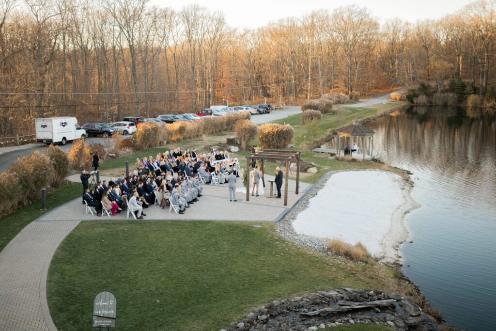 Emily and Frank Rock Island Lake Club, NJ 
Winter weddings are magical, and Emily and Frank’s November celebration at Rock Island Lake Club in Sparta, NJ, was the perfect example of just how enchanting they can be! Who says winter weddings can’t be fun? Despite the chilly weather, their special day was filled with warmth, laughter, and love—a true testament to their joyful spirits and the magic of this incredible venue.
Emily and Frank embraced the crisp November air with an outdoor ceremony by the picturesque lake at Rock Island Lake Club. The serene water, framed by the natural beauty of the surrounding landscape, created an unforgettable backdrop for their vows. Guests bundled up in cozy wraps and blankets, their smiles radiating as they witnessed the couple’s heartfelt promises. The venue’s dedicated team ensured every detail was perfectly executed, making the ceremony seamless.
After the ceremony, the celebration continued with one of the best cocktail hours in all of New Jersey. Rock Island Lake Club is renowned for its exceptional cuisine and creative presentation, and this event was no exception. Guests enjoyed an array of delicious hors d’oeuvres and drinks while mingling in the warm and inviting indoor spaces, thoughtfully designed to complement the venue’s lakeside charm.
The reception was a lively affair, with the dance floor packed from the first song to the last. Friends and family came together to celebrate Emily and Frank’s love, creating an atmosphere of pure joy. The stunning reception room at Rock Island Lake Club, with its elegant décor and large windows overlooking the lake, provided the perfect setting for a night of dancing, laughter, and unforgettable memories.
Rock Island Lake Club truly excels at hosting weddings year-round, but winter weddings here have a special kind of magic. From the attentive staff to the breathtaking views, every aspect of this venue enhances the celebration. Emily and Frank’s wedding day is proof that even on the coldest days, love and happiness can shine brighter than ever.
If you’re considering a winter wedding, Rock Island Lake Club is the perfect venue to bring your vision to life. Emily and Frank’s celebration was a testament to the beauty of the season and the power of love to warm even the chilliest of days.
Emily and Frank Rock Island Lake Club NJ Wedding photographed by Steve from Pearl Paper Studio. Pearl Paper Studio is here to capture real emotions, fun couples with non-traditional wedding stories, now we are booking small intimate backyard wedding, outdoor tent wedding, farm wedding, elopements, nyc elopements. We are currently booking 2025 and 2026 weddings in NJ, Manhattan, Hudson Valley NY, Brooklyn and Long Island.
