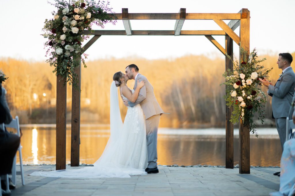 Emily and Frank Rock Island Lake Club, NJ 
Winter weddings are magical, and Emily and Frank’s November celebration at Rock Island Lake Club in Sparta, NJ, was the perfect example of just how enchanting they can be! Who says winter weddings can’t be fun? Despite the chilly weather, their special day was filled with warmth, laughter, and love—a true testament to their joyful spirits and the magic of this incredible venue.
Emily and Frank embraced the crisp November air with an outdoor ceremony by the picturesque lake at Rock Island Lake Club. The serene water, framed by the natural beauty of the surrounding landscape, created an unforgettable backdrop for their vows. Guests bundled up in cozy wraps and blankets, their smiles radiating as they witnessed the couple’s heartfelt promises. The venue’s dedicated team ensured every detail was perfectly executed, making the ceremony seamless.
After the ceremony, the celebration continued with one of the best cocktail hours in all of New Jersey. Rock Island Lake Club is renowned for its exceptional cuisine and creative presentation, and this event was no exception. Guests enjoyed an array of delicious hors d’oeuvres and drinks while mingling in the warm and inviting indoor spaces, thoughtfully designed to complement the venue’s lakeside charm.
The reception was a lively affair, with the dance floor packed from the first song to the last. Friends and family came together to celebrate Emily and Frank’s love, creating an atmosphere of pure joy. The stunning reception room at Rock Island Lake Club, with its elegant décor and large windows overlooking the lake, provided the perfect setting for a night of dancing, laughter, and unforgettable memories.
Rock Island Lake Club truly excels at hosting weddings year-round, but winter weddings here have a special kind of magic. From the attentive staff to the breathtaking views, every aspect of this venue enhances the celebration. Emily and Frank’s wedding day is proof that even on the coldest days, love and happiness can shine brighter than ever.
If you’re considering a winter wedding, Rock Island Lake Club is the perfect venue to bring your vision to life. Emily and Frank’s celebration was a testament to the beauty of the season and the power of love to warm even the chilliest of days.
Emily and Frank Rock Island Lake Club NJ Wedding photographed by Steve from Pearl Paper Studio. Pearl Paper Studio is here to capture real emotions, fun couples with non-traditional wedding stories, now we are booking small intimate backyard wedding, outdoor tent wedding, farm wedding, elopements, nyc elopements. We are currently booking 2025 and 2026 weddings in NJ, Manhattan, Hudson Valley NY, Brooklyn and Long Island.
