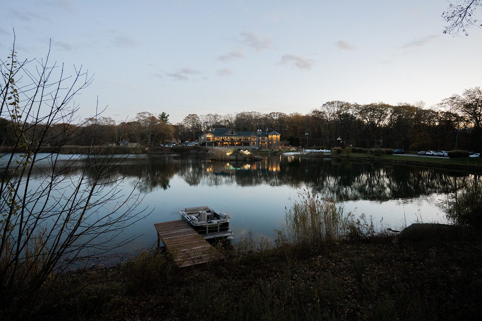 Evening lake view of Rock Island Lake Club with the dock and venue lights reflected across the water.