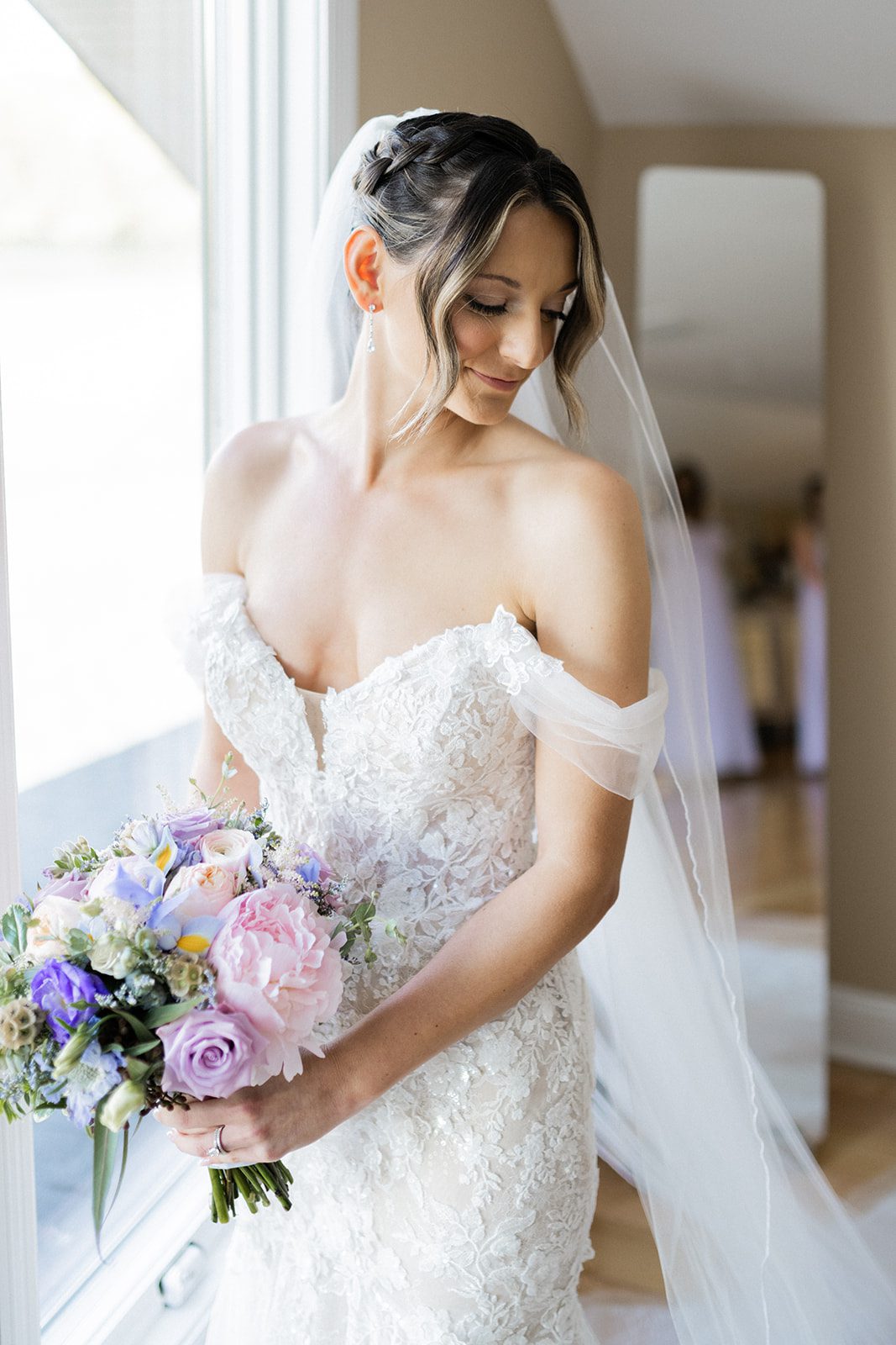 Heather Bridal Portrait With Bouquet Heather poses in her lace gown while holding her pastel bouquet.