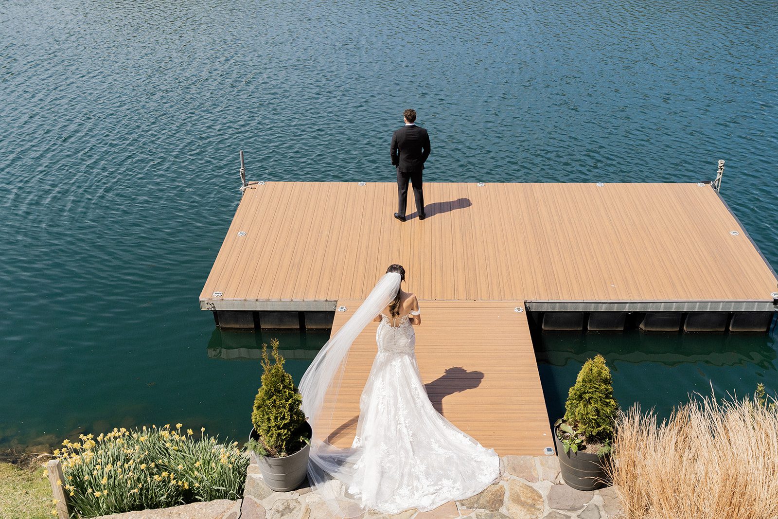 Heather and Michael stand together on the dock with the lake behind them.
