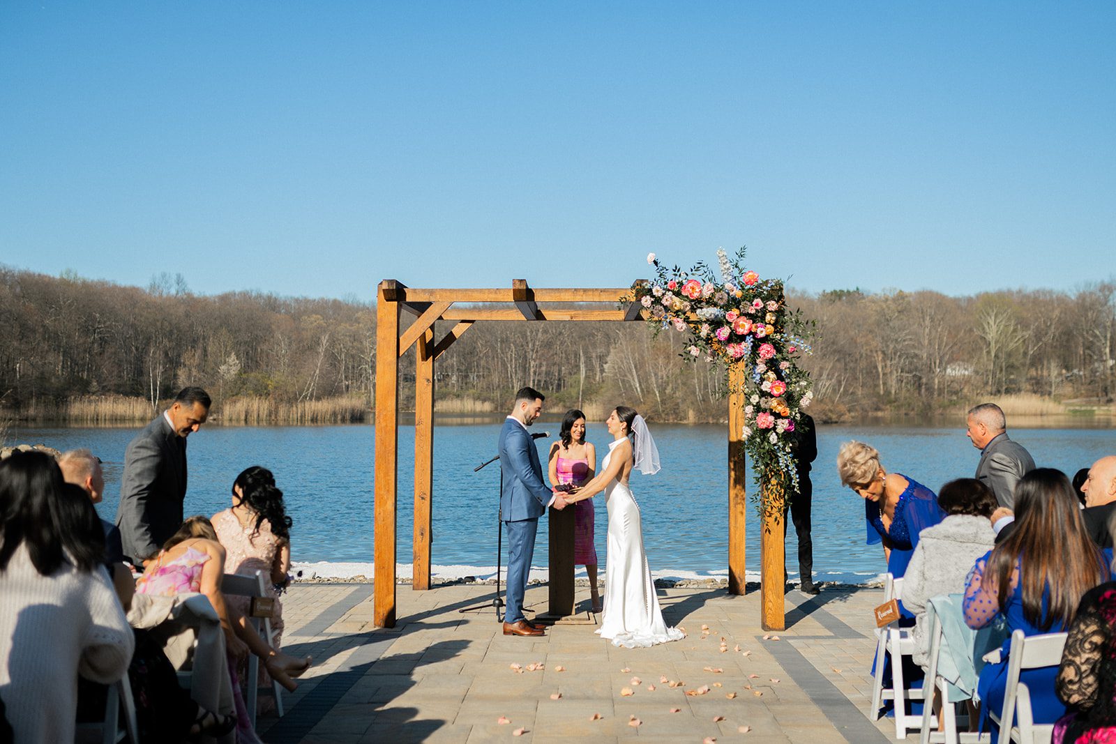 Wide view of Gabriella and Joseph at their lakeside ceremony.